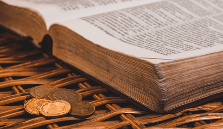 open Bible with coins next to it