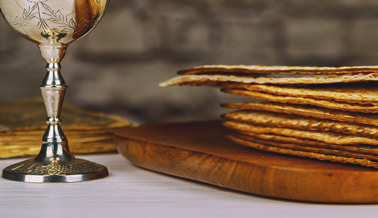 silver goblet next to unleavened bread