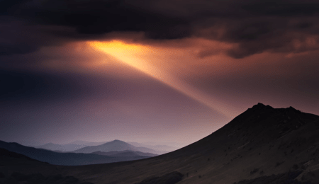 mountain scape with sunbeam shining through clouds